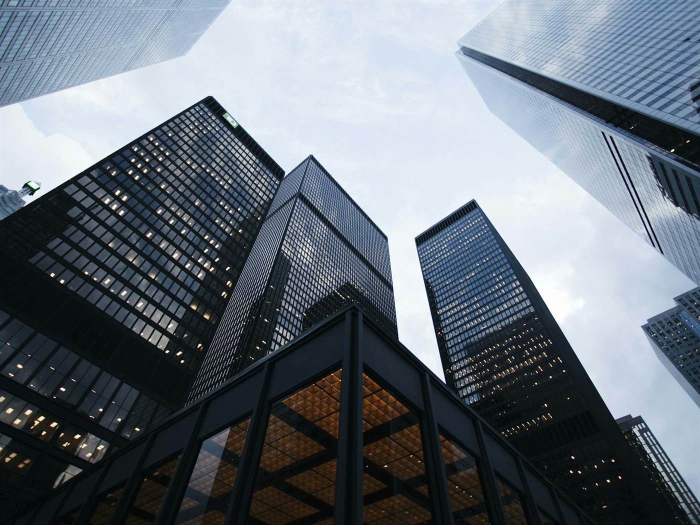 Tall office towers photographed from street level against a pale sky
