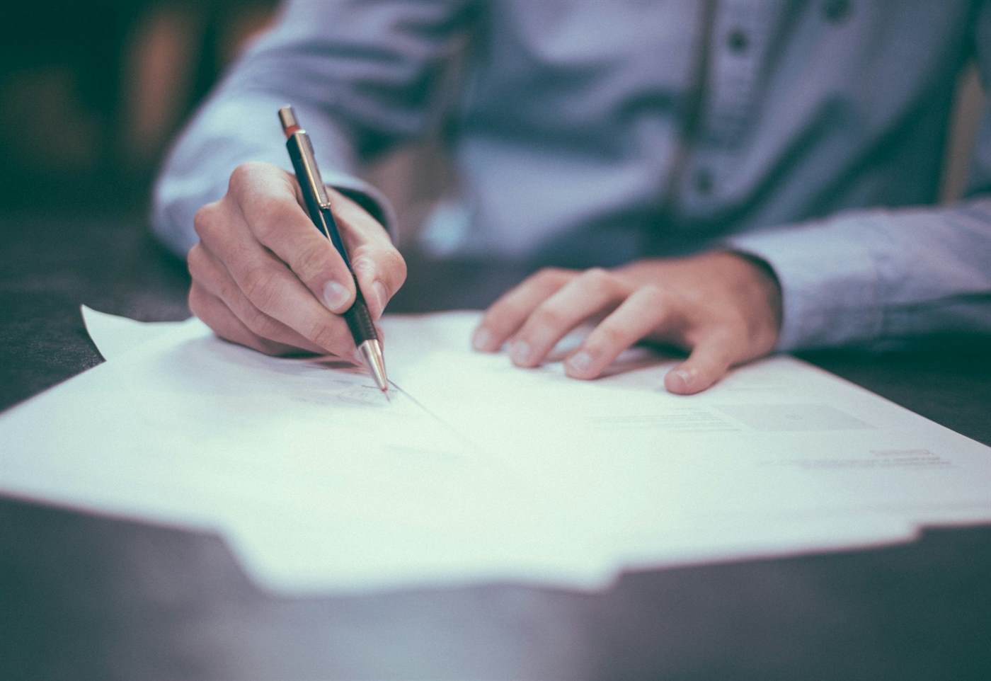 Close view of a person marking a printed document with a pen